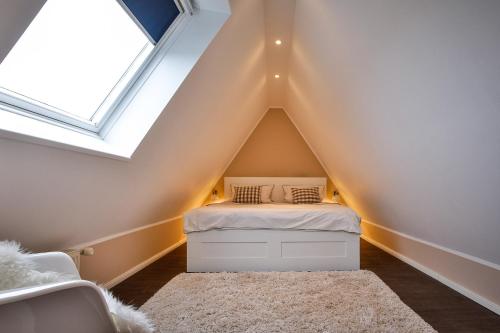 Un pequeño dormitorio con una cama en el ático. en Inselloft, en Hörnum