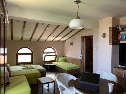 a bedroom with two beds and a laptop on a table at BRUNETTE BEAUTIES Guesthouse & Studio Sinemorets in Sinemorets