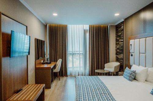 a hotel room with a bed and a desk at King Solomon Batumi Hotel in Batumi