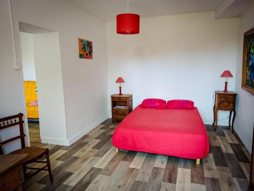 a bedroom with a red bed with red pillows at la petite maison d'Albert in La Motte-Saint-Jean