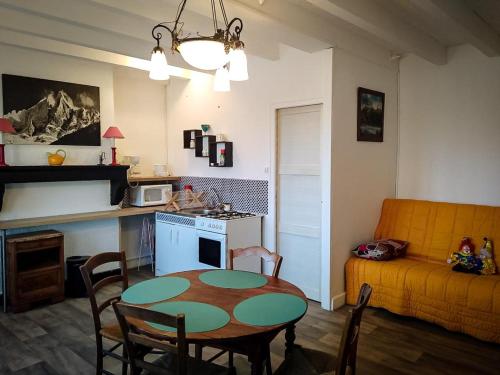a kitchen and living room with a table and a couch at la petite maison d'Albert in La Motte-Saint-Jean