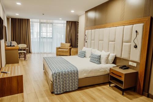 a hotel room with a bed and a chair at King Solomon Batumi Hotel in Batumi