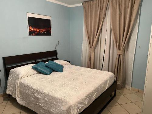 een slaapkamer met een bed met twee blauwe kussens erop bij Eco del ponte in Sasso di Castalda