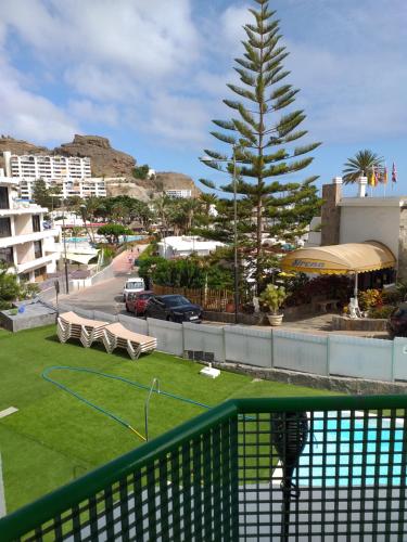 莫甘的住宿－Balcón Puerto Rico Playa Mogán，阳台设有绿色的围栏和树