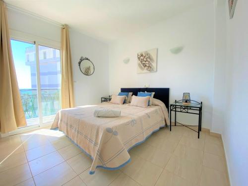 - une chambre avec un lit et une grande fenêtre dans l'établissement Apartamento PAOLA Calpe, à Calp