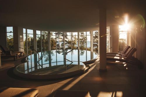 a hot tub in the middle of a room with windows at Strandhotel Ostseeblick in Heringsdorf