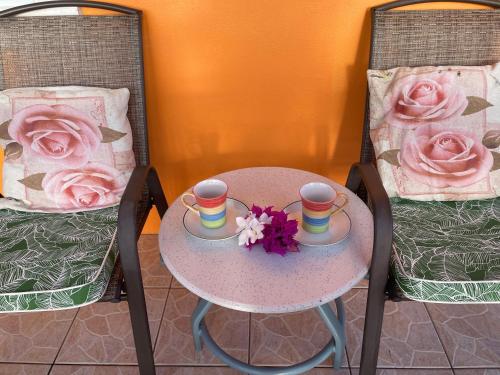 a table with two chairs and two cups and flowers on it at Sunrise Suite in Gros Islet