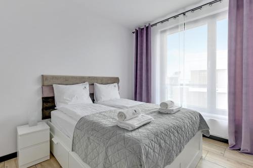 una camera da letto con un letto e asciugamani di Lion Apartments - Botanica a Danzica