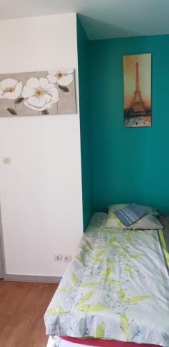 a bedroom with a bed with a picture of the eiffel tower at Studio de 12m² agréable calme proche CHU in Dijon
