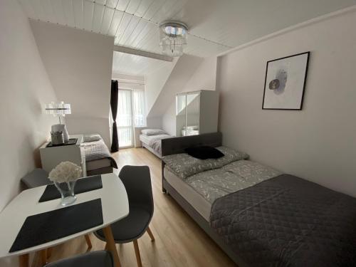 a bedroom with two beds and a desk and a table at Dom gościnny Jarek in Rowy