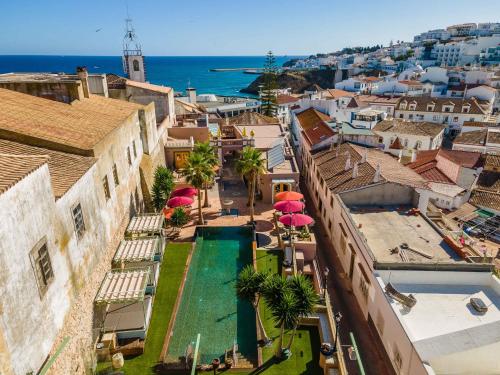 an aerial view of a city with a swimming pool at Vila Origens Boutique Hotel Albufeira – Adults Only in Albufeira