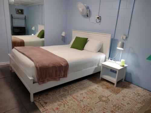 sypialnia z białym łóżkiem z zielonymi poduszkami w obiekcie Meigs19 Lodge w mieście Stuart Park