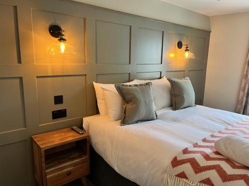 a bedroom with a white bed with a wooden table at The Punchbowl Inn in Woodstock