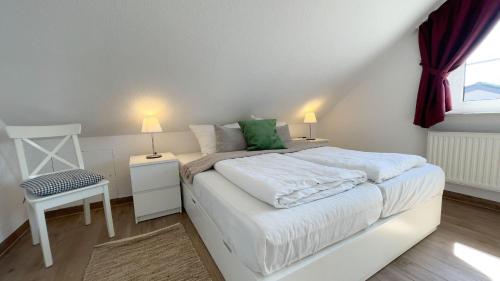 una camera con un letto bianco e una finestra di Haus-Kirsten-Fewo-Nr-5 a Cuxhaven