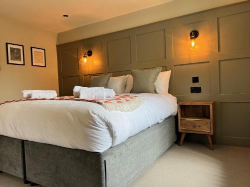 a bedroom with a large bed with white sheets at The Punchbowl Inn in Woodstock