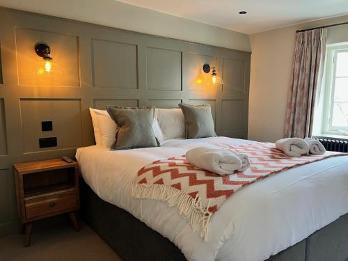 a bedroom with a large bed with two towels on it at The Punchbowl Inn in Woodstock