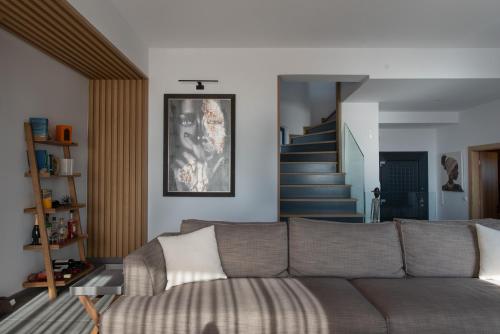 a living room with a couch and a staircase at Mirazur Seafront Sunset Villa in Preveza
