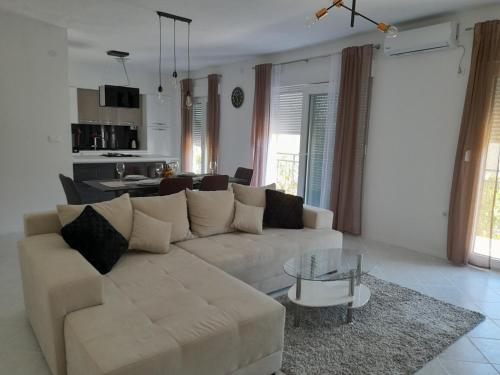 a living room with a white couch and a table at sunny holiday in Vinišće