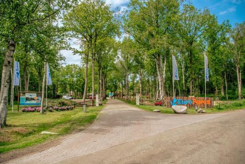 a dirt road in a park with trees and signs at EuroParcs Ruinen in Ruinen