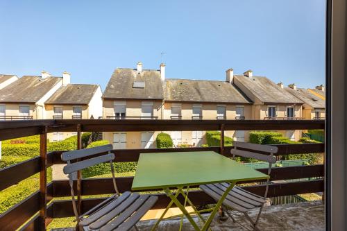 - un balcon avec une table et des chaises dans l'établissement Le Sloop, à Courseulles-sur-Mer