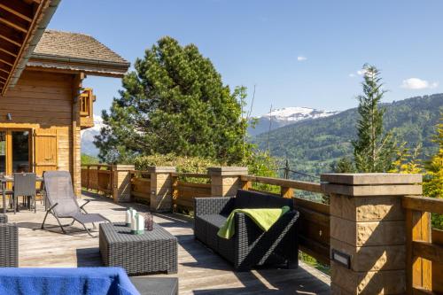 a patio with furniture and a view of mountains at Chalet Taninges in Taninges