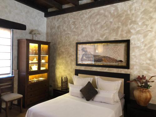 een slaapkamer met een bed met witte lakens en een kast bij Cigarral los Segadores in Casarrubios del Monte