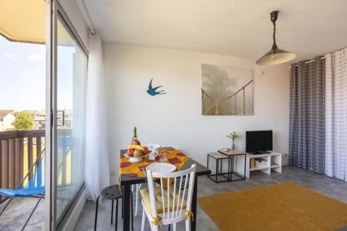 une salle à manger avec une table et une vue sur le pont de la porte dorée. dans l'établissement Sunan, à Courseulles-sur-Mer