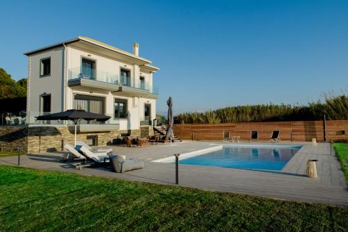 a house with a swimming pool in the yard at Mirazur Seafront Sunset Villa in Preveza