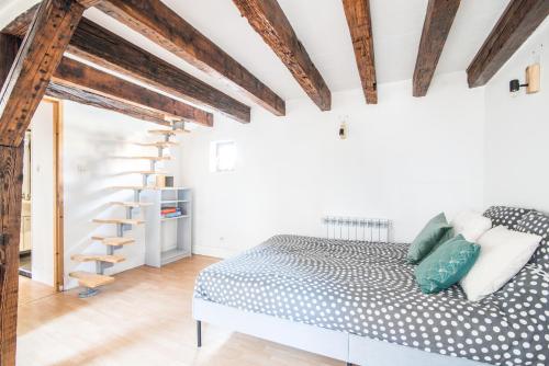 - une chambre avec un lit et des poutres apparentes dans l'établissement La Petite Cathédrale Strasbourg séjour de 30 jours ou plus, à Strasbourg