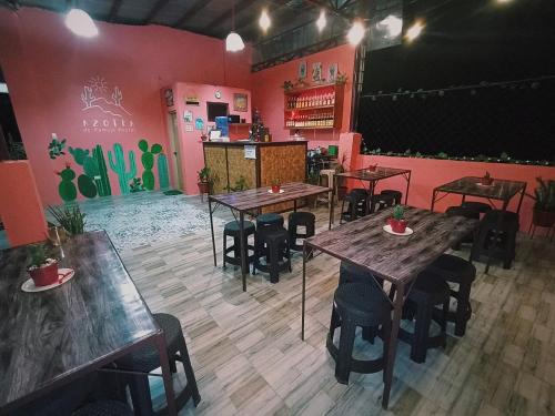 a restaurant with wooden tables and chairs and pink walls at Pamujo Hostel in Baclayon
