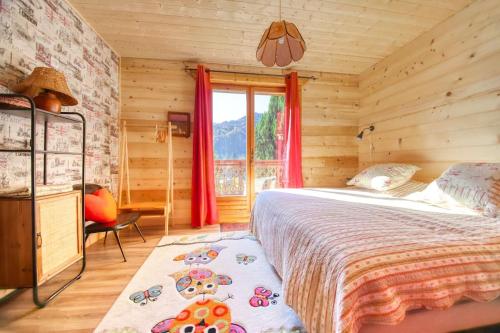 um quarto com uma cama grande e uma janela em chez Lily em Samoëns