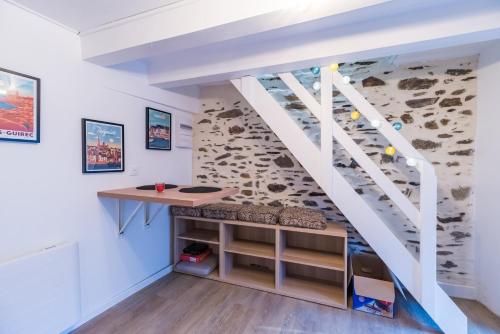 Habitación con escritorio bajo una escalera. en Logement Duplex au cœur de Tréguier, en Tréguier