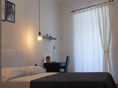 een slaapkamer met een bed, een bureau en een raam bij DonPè in Agrigento