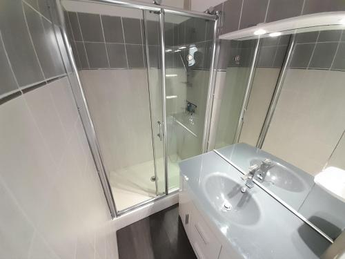 une salle de bain blanche avec une douche et un lavabo dans l'établissement Studio Village Naturiste Resille, au Cap d'Agde