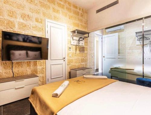 una camera con letto e TV a parete di Nigret Step’n’Suites a Żurrieq