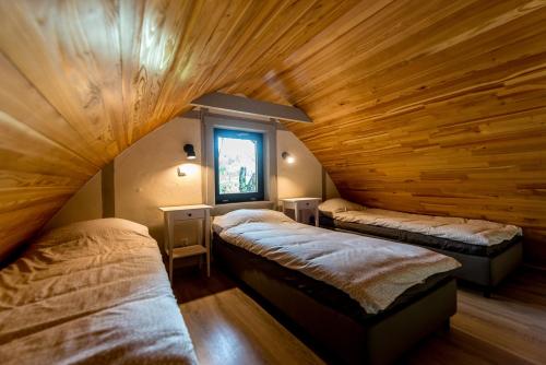 two beds in a room with wooden ceilings at Sen i Wino in Żywiec