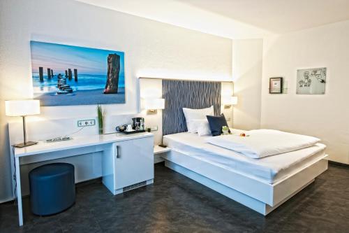 ダルムシュタットにあるHotel Jungstilのベッドとデスクが備わるホテルルームです。