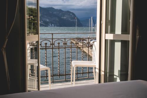 a bedroom with a view of the ocean from a balcony at Araba Fenice Hotel in Iseo