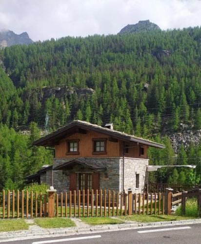 a house with a fence in front of a mountain at La terrazza in Ceresole Reale
