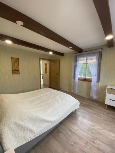 Un dormitorio con una cama grande y una ventana en Bangomūša, en Nida