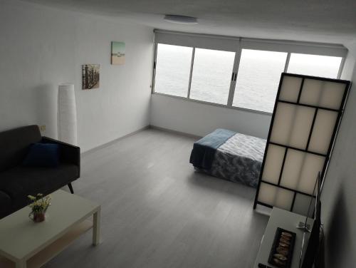 SUNSET HOME wifi في لوس رياليخوس: غرفة معيشة مع سرير وأريكة
