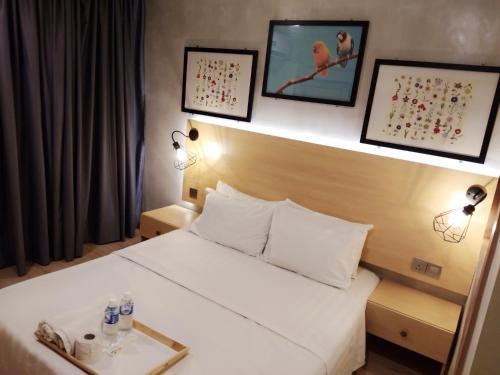 a hotel room with a bed with a tray on it at Raintree Boutique Hotel in Kajang
