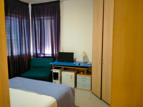 Schlafzimmer mit einem Bett und einem Schreibtisch mit einem Laptop in der Unterkunft CASA DE NELLA in Porto San Giorgio
