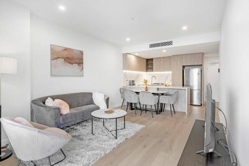 a living room with a couch and a table at Lamour Ocean View Apartment II in Casino Broadbeach - free parking-195cm in Gold Coast