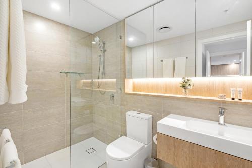 a bathroom with a toilet and a sink and a mirror at Lamour Ocean View Apartment II in Casino Broadbeach - free parking-195cm in Gold Coast