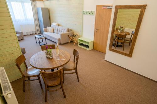 a room with a table and chairs and a living room at Penzion Maria in Liptovský Mikuláš