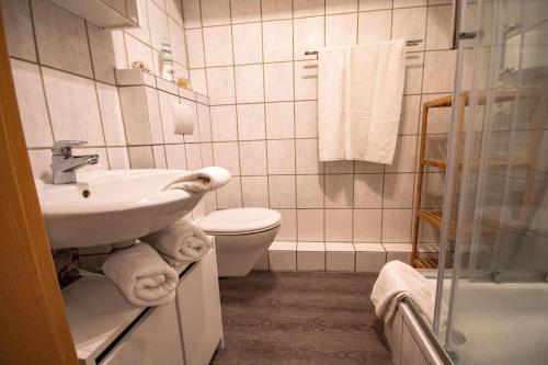 a bathroom with a sink and a toilet and towels at Neue-Reihe-8-rechts in Cuxhaven