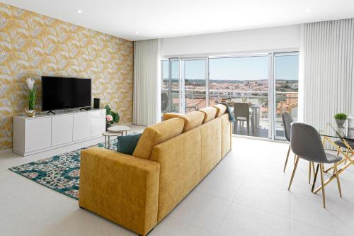 a living room with a couch and a television at Pérola da Nazaré in Nazaré