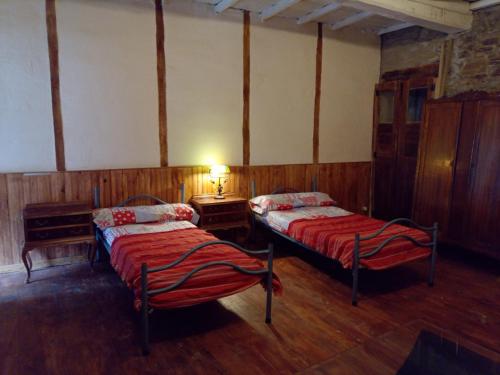um quarto com duas camas e um candeeiro em Cabaña del Zapatero El Bierzo Ponferrada em Valdecañada