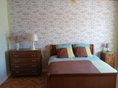 - une chambre avec un lit et un mur en briques dans l'établissement Les Clés de Clessé, à Clessé